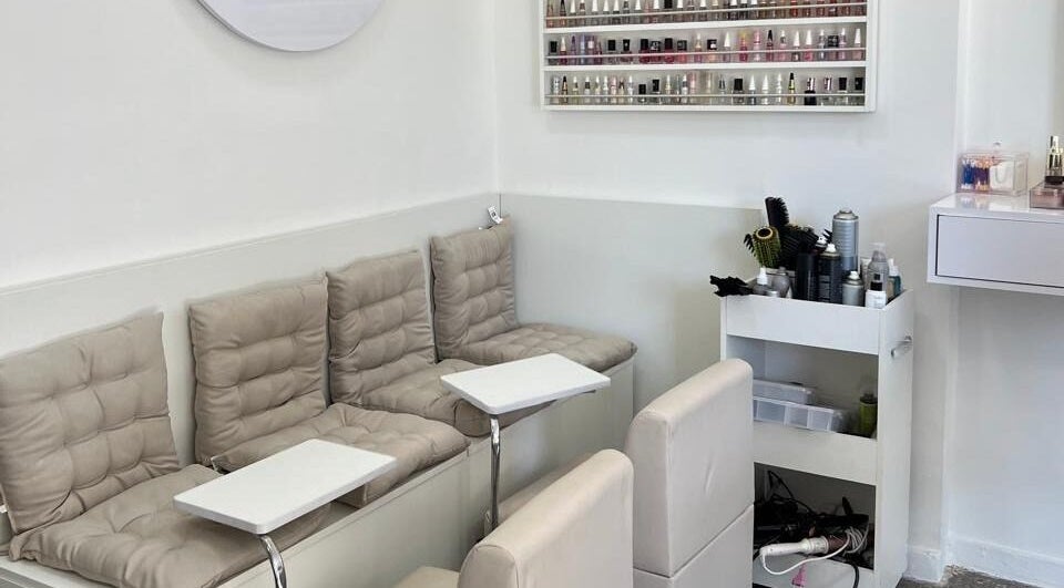 Interior acolhedor do Donna Studio de beleza no Distrito Federal, BR, com assentos e prateleira de esmaltes.