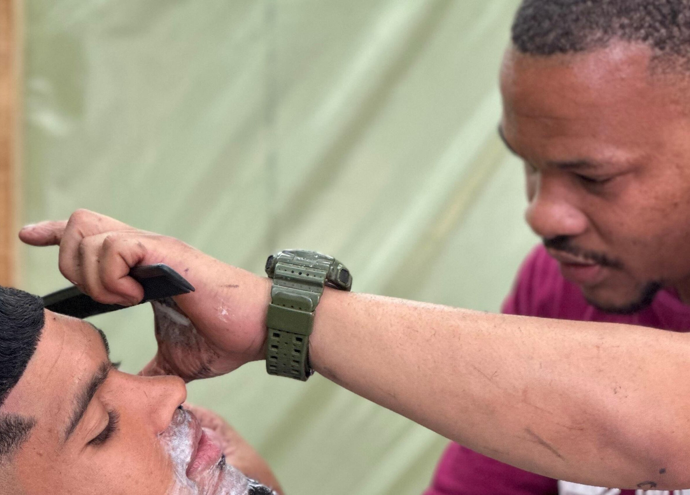Professional barber at Incredible Haircuts, Stellenbosch, Western Cape, ZA carefully styles a customer's hair.