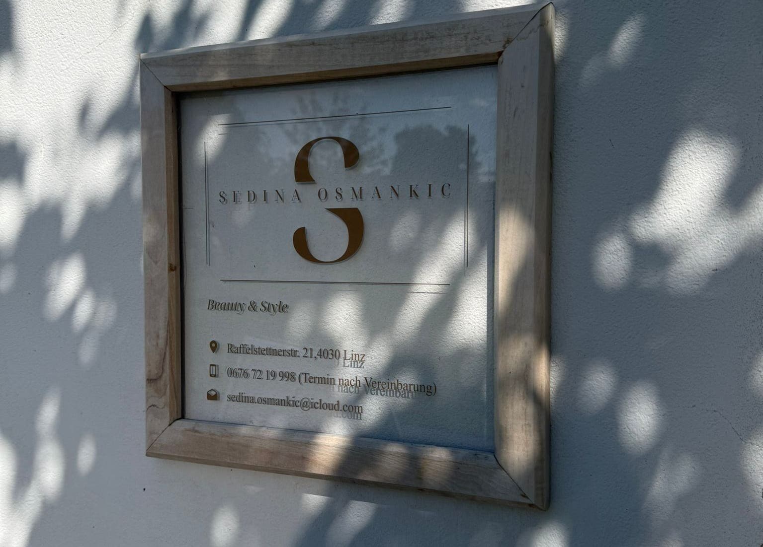 Elegantes Schild von Beauty & Style an der Wand in Linz - Pichling, Oberösterreich, AT mit Schatten.