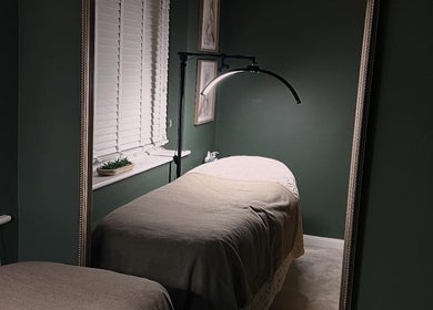 Relaxing treatment room at DANA Skin & Aesthetics, Ripon, England, GB, featuring a cozy bed with soft lighting.