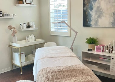 Tranquil treatment room at Refresh Skin, Carlsbad, California, US with a comfortable bed and skincare products.