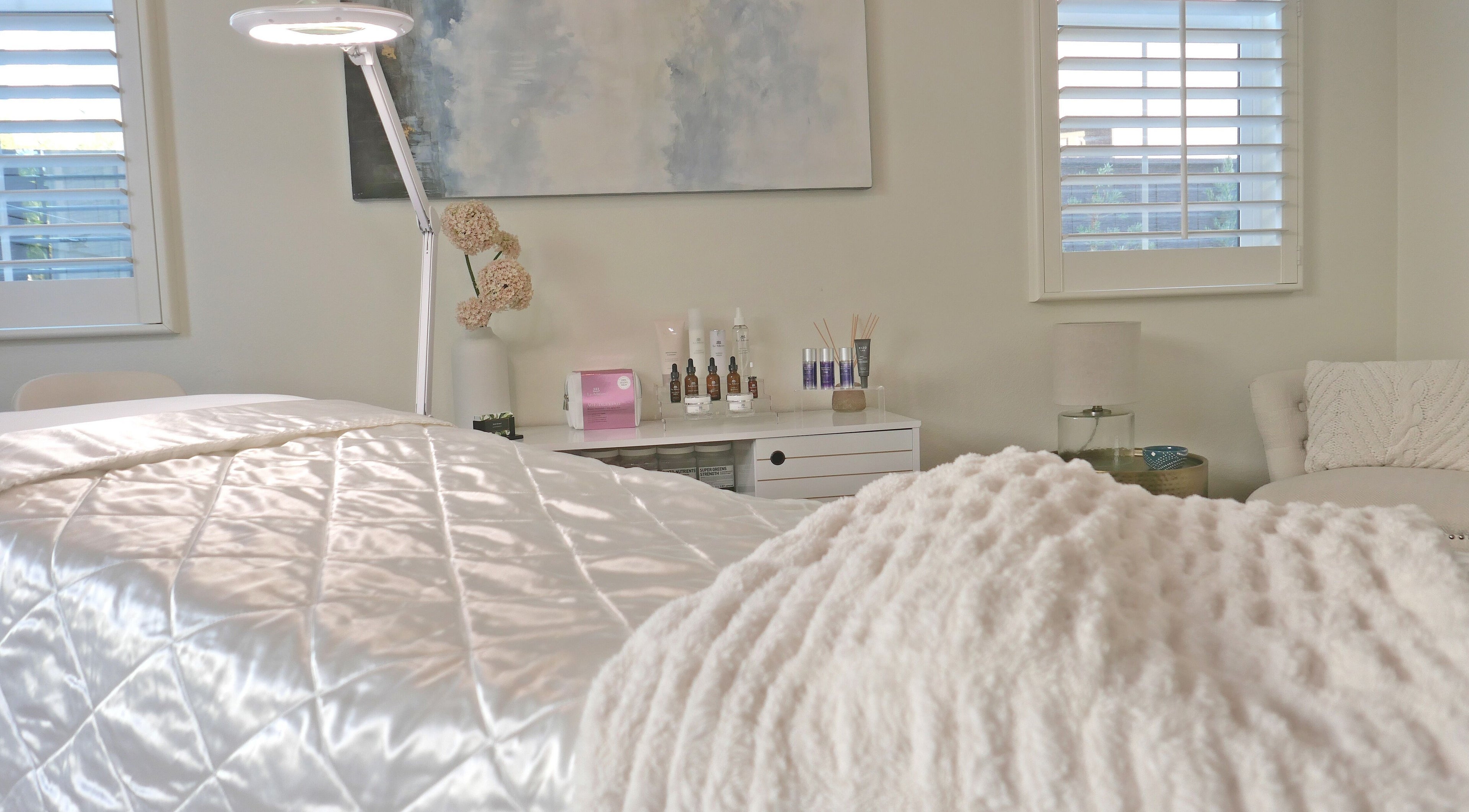 Cozy treatment room at Refresh Skin, Carlsbad, California, US, featuring soft light and skincare products.