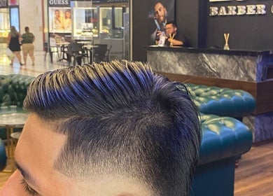 Cliente con estilo moderno en The barber 09, Neiva, Huila, CO, frente al mostrador decorativo.
