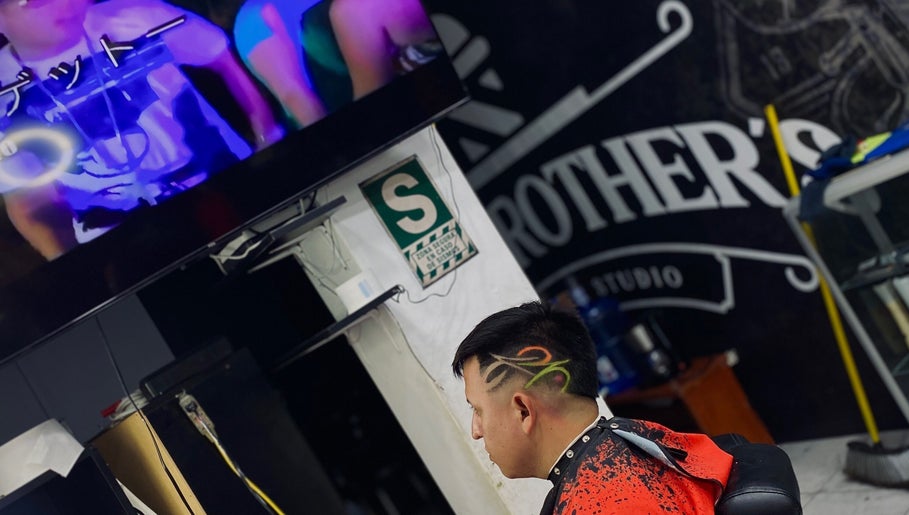 Cliente en Joex, Chimbote, PE, luciendo corte de cabello artístico con diseño colorido en los costados.