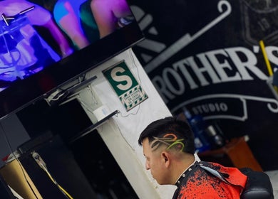 Cliente en Joex, Chimbote, PE, luciendo corte de cabello artístico con diseño colorido en los costados.