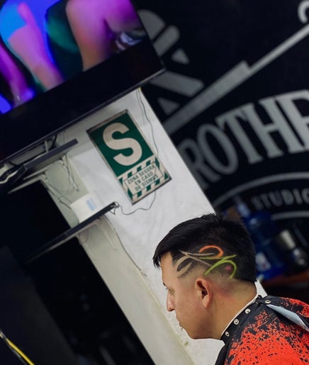 Cliente en Joex, Chimbote, PE, luciendo corte de cabello artístico con diseño colorido en los costados.