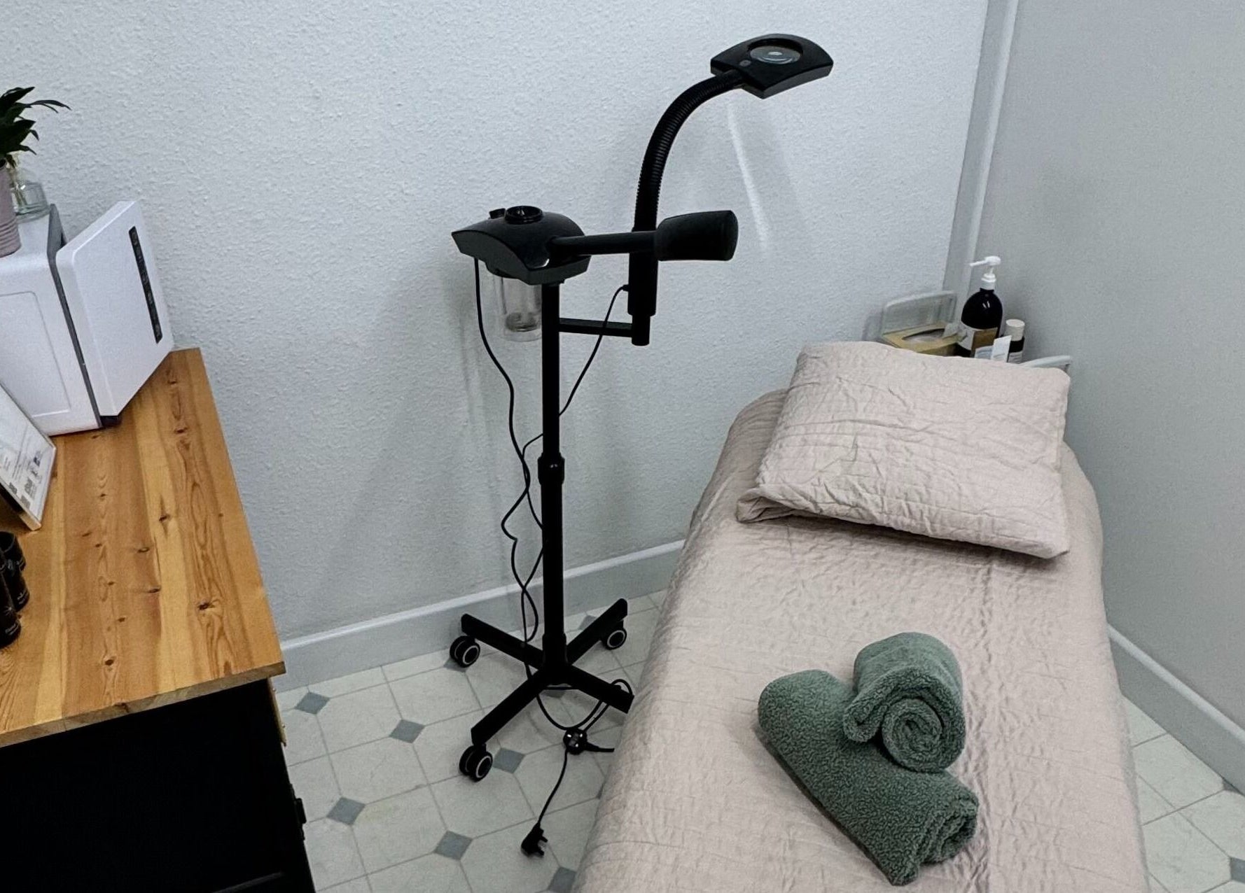 Cozy treatment room at The Beauty Feel With Iryna, Redruth, England. Relaxing setup with bed and green towels.