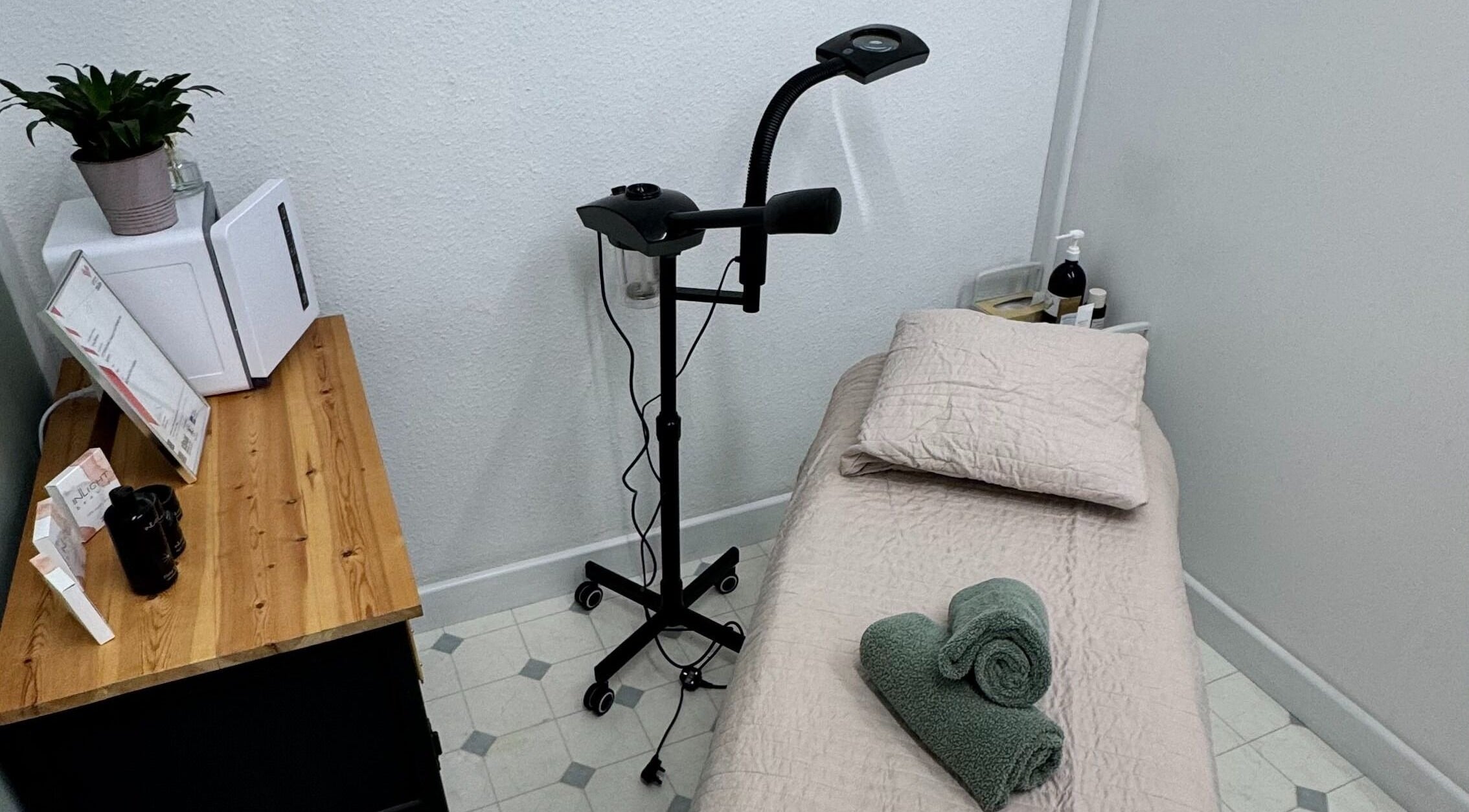 Cozy treatment room at The Beauty Feel With Iryna, Redruth, England. Relaxing setup with bed and green towels.