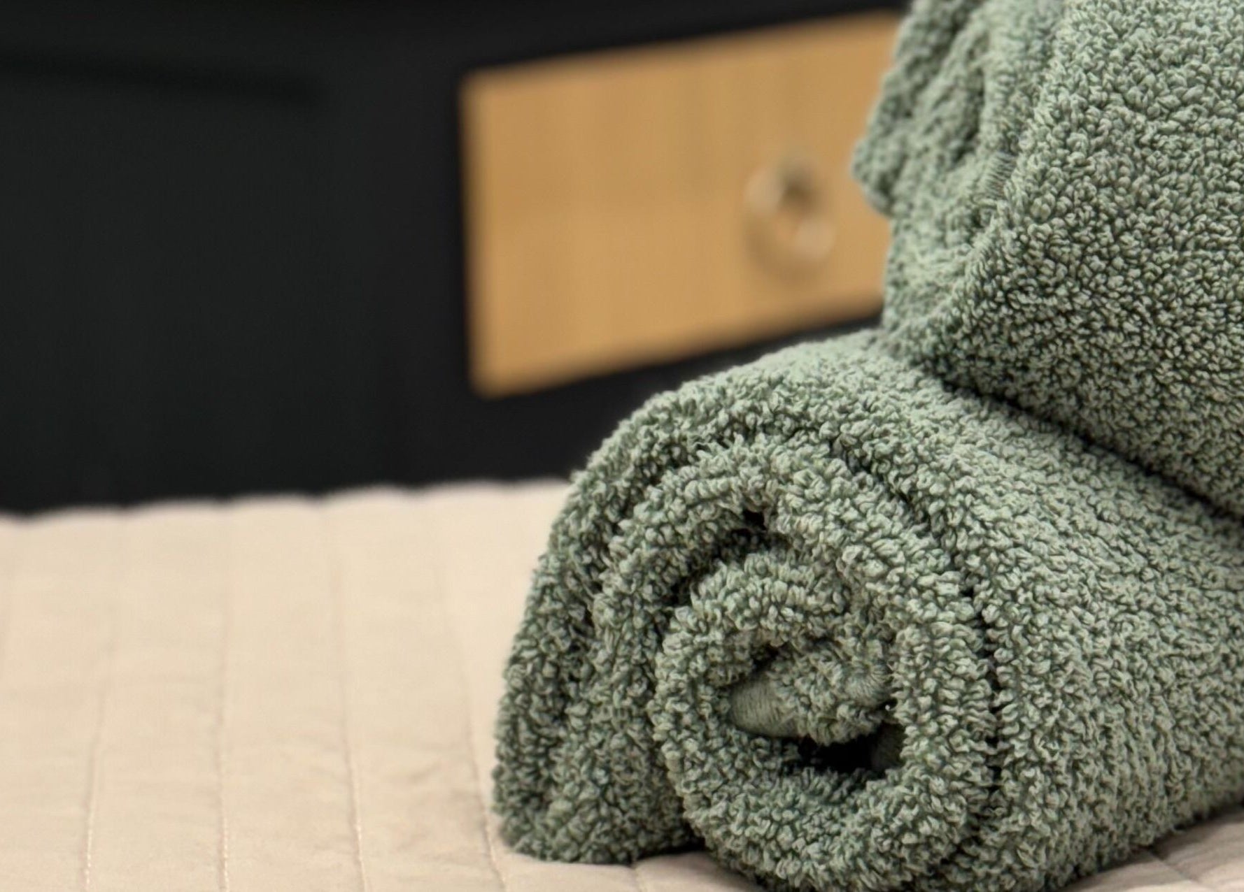 Green rolled towels at The Beauty Feel With Iryna in Redruth, England, GB enhance relaxation.