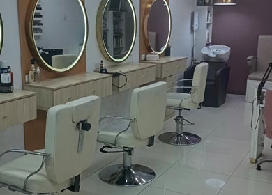 Elegante salón de belleza en Sin límites, Miraflores, Provincia De Lima, PE, con sillas blancas y espejos circulares.