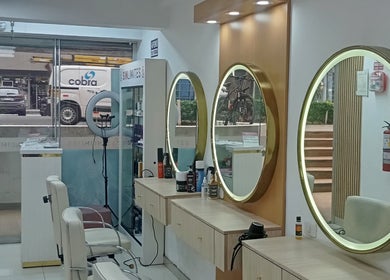 Interior del salón Sin límites en Miraflores, Provincia De Lima, PE con espejos redondos iluminados.
