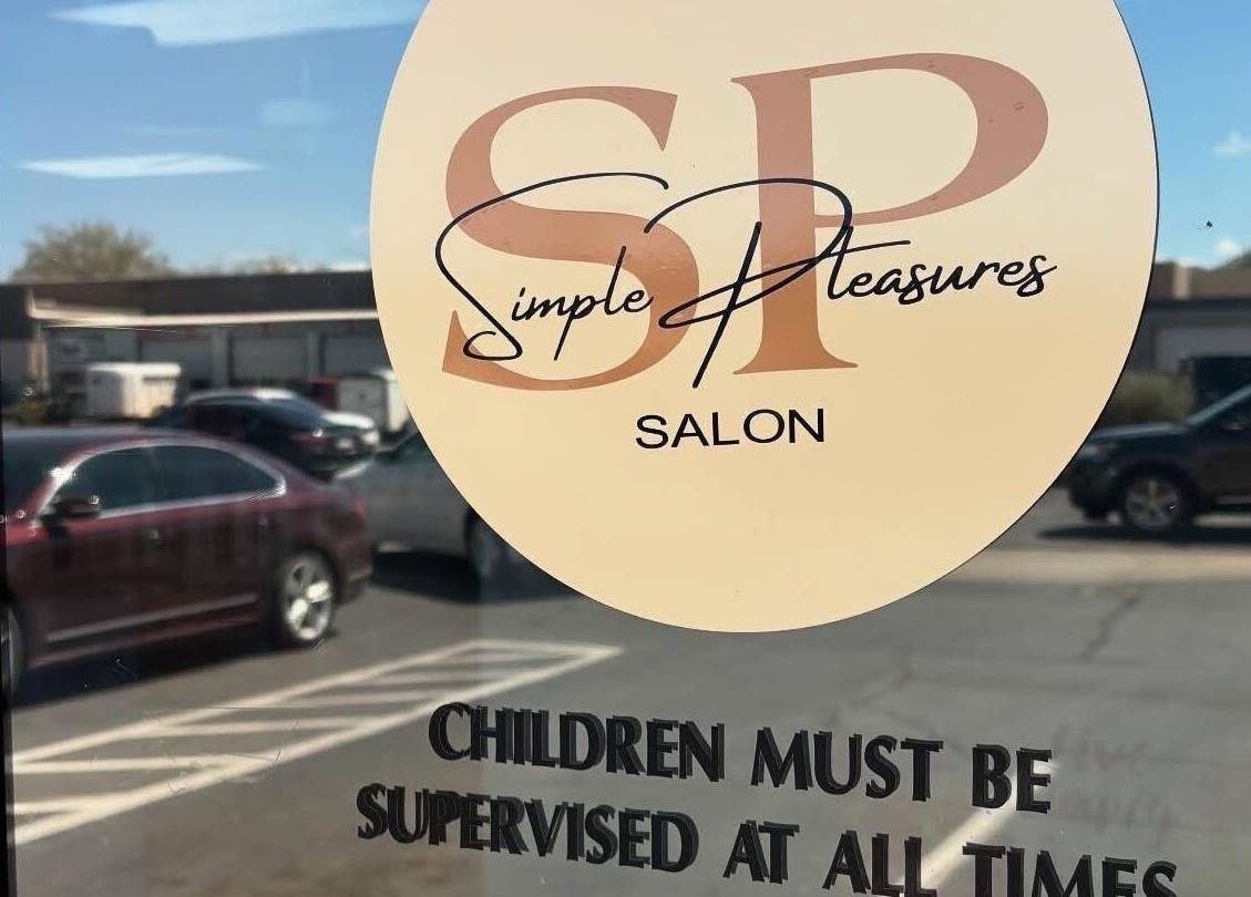 Entrance of KT Perfectly Polished salon in Hurricane, Utah, showing window decal with hours and name.