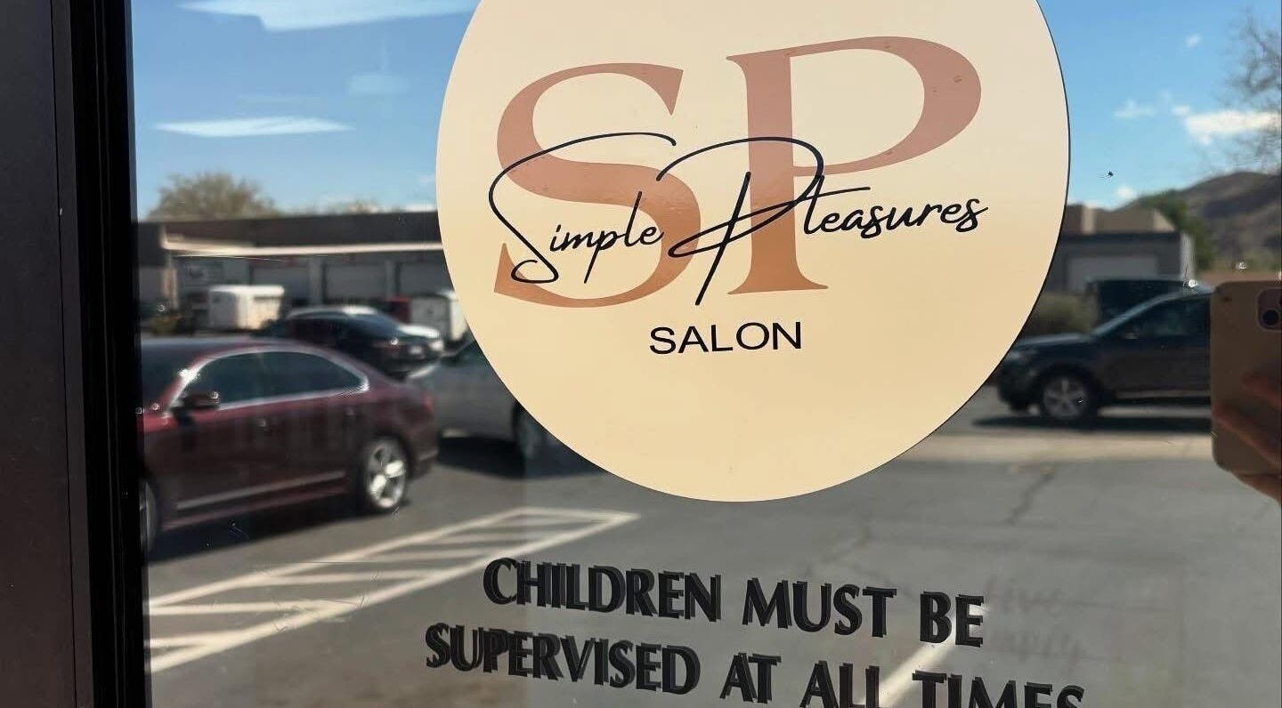 Entrance of KT Perfectly Polished salon in Hurricane, Utah, showing window decal with hours and name.