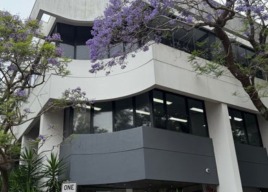 Exterior of Mojo Cosmetic Clinic, Neutral Bay, New South Wales, AU, surrounded by lush purple jacaranda trees.