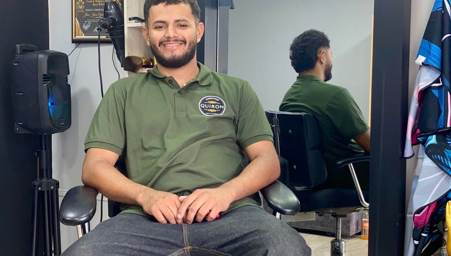 Barbero sonriendo en Quironbarbershop, Guadalajara De Buga, Valle Del Cauca, CO. Ambiente profesional y acogedor.