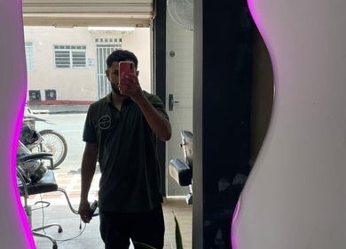 Interior de Quironbarbershop en Guadalajara De Buga, Valle Del Cauca, CO, mostrando un espejo con luz morada.