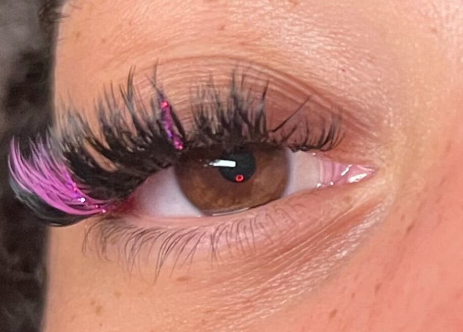 Closeup of glamorous eyelash extensions with pink accents at Eye Candy Lashes in Barrie, Ontario, CA.