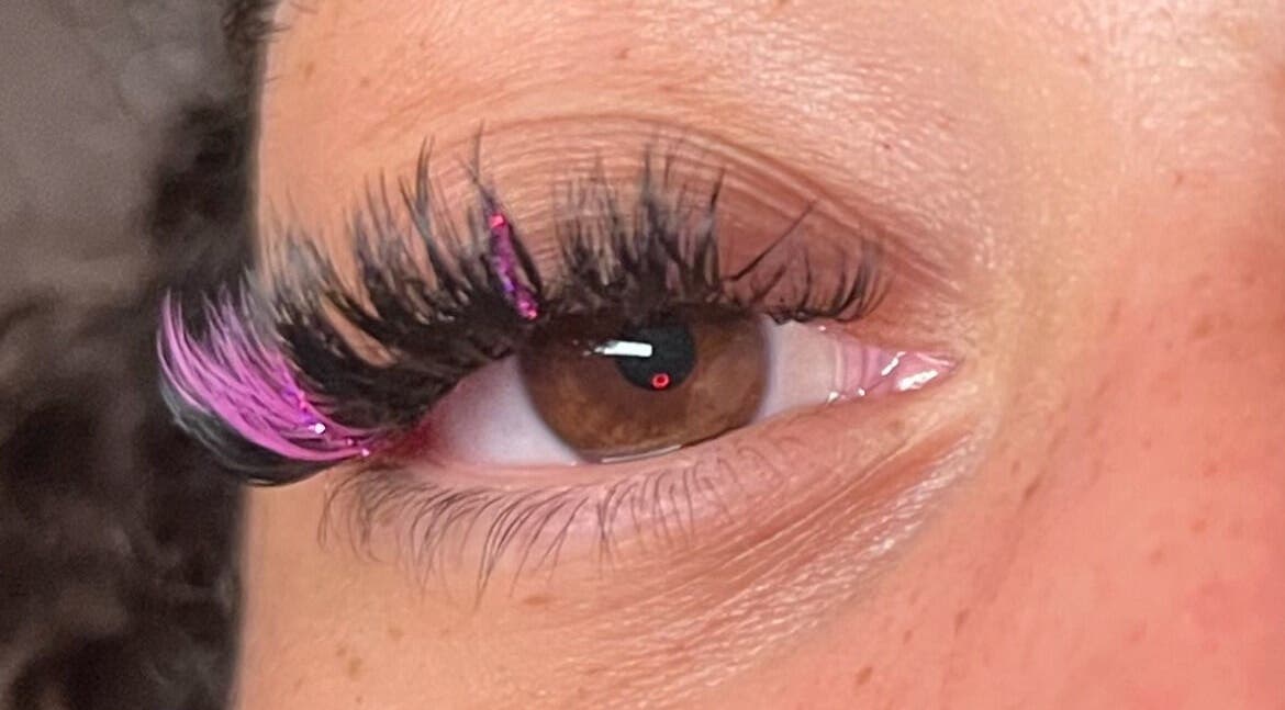Closeup of glamorous eyelash extensions with pink accents at Eye Candy Lashes in Barrie, Ontario, CA.