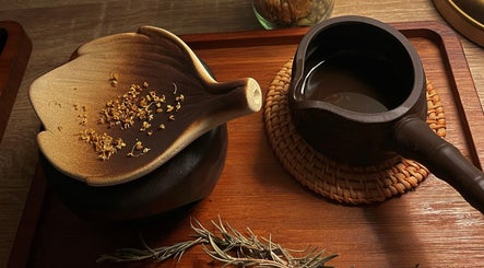 A serene herbal tea setup at Pearl BodyCare in Bunbury, Western Australia, AU, featuring rustic dishware.