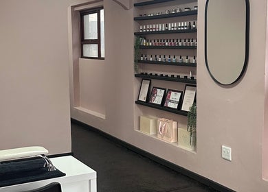 Interior of Alae Aesthetics & Cosmetics in Gqeberha, featuring a stylish nail polish display and mirror.