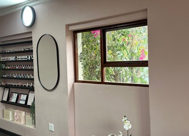 Interior of Alae Aesthetics & Cosmetics in Gqeberha, Eastern Cape, ZA, featuring nail polish display and mirror.