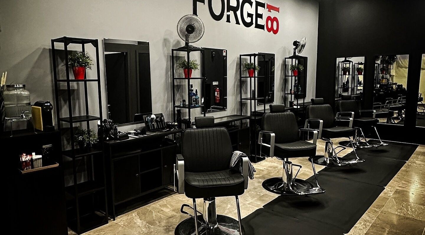 Interior moderno de Forge81 Barbershop, Porto, PT, com cadeiras e espelhos estilizados.