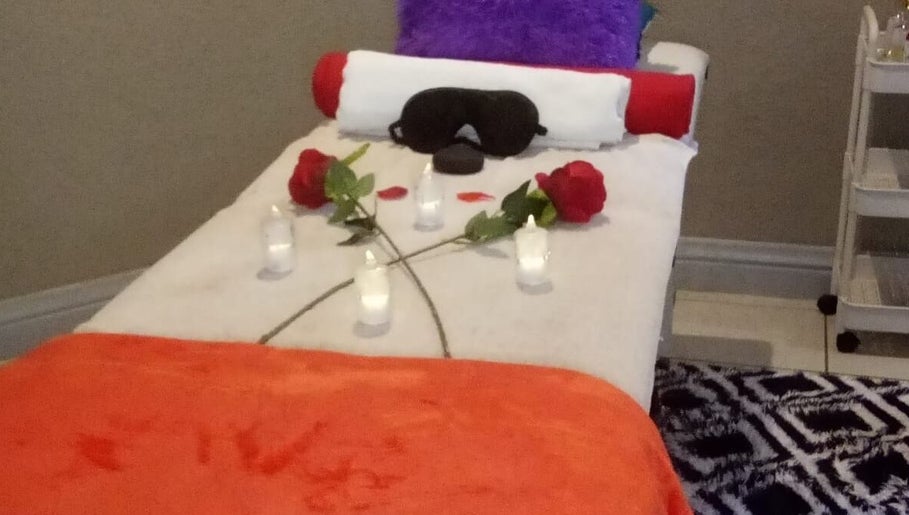 Tranquil massage bed setup at Magical Haven Spa, Johannesburg, Gauteng, ZA with candles and roses.