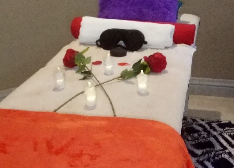 Tranquil massage bed setup at Magical Haven Spa, Johannesburg, Gauteng, ZA with candles and roses.