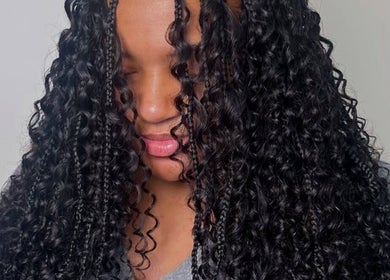 Femme avec coiffure boucle afro au salon LB à Toulouse, FR, mettant en valeur des cheveux noirs brillants.