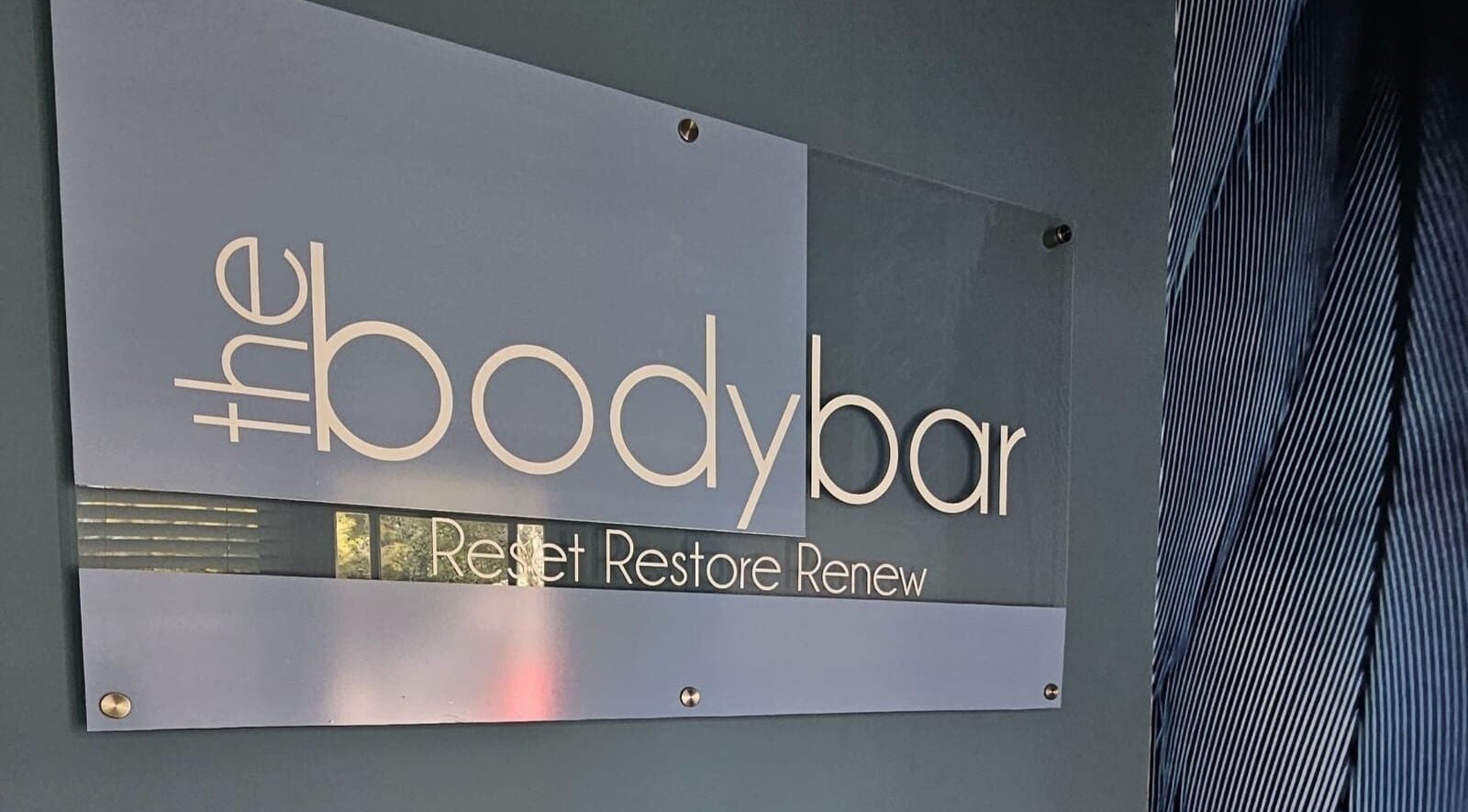 Elegant signage of The Body Bar in Gqeberha, Eastern Cape, ZA featuring the phrase 'Reset Restore Renew'.