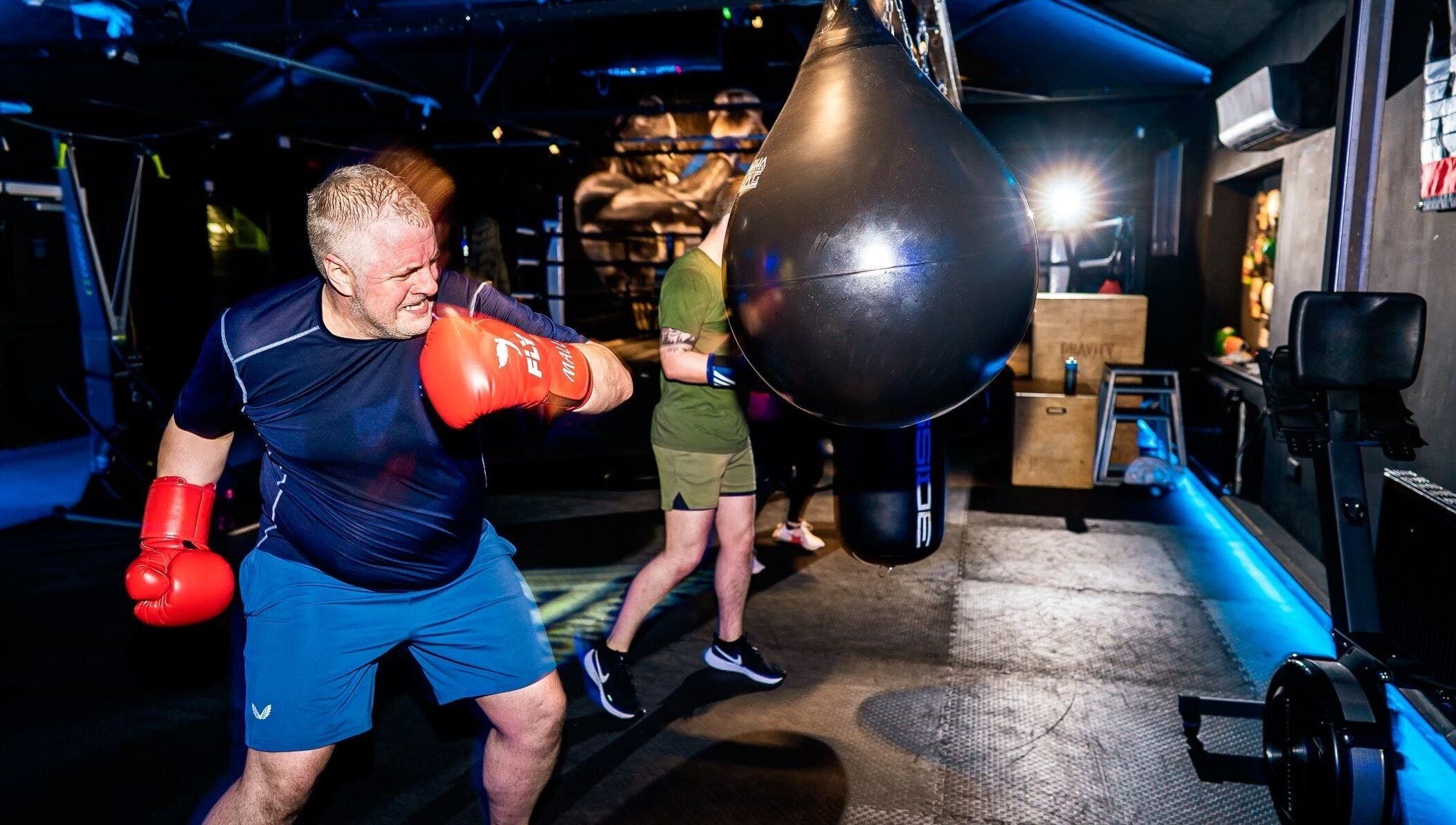 Man boxing at Conquer Boxing & Fitness, Ormskirk, England. Engaged in punching bag workout.