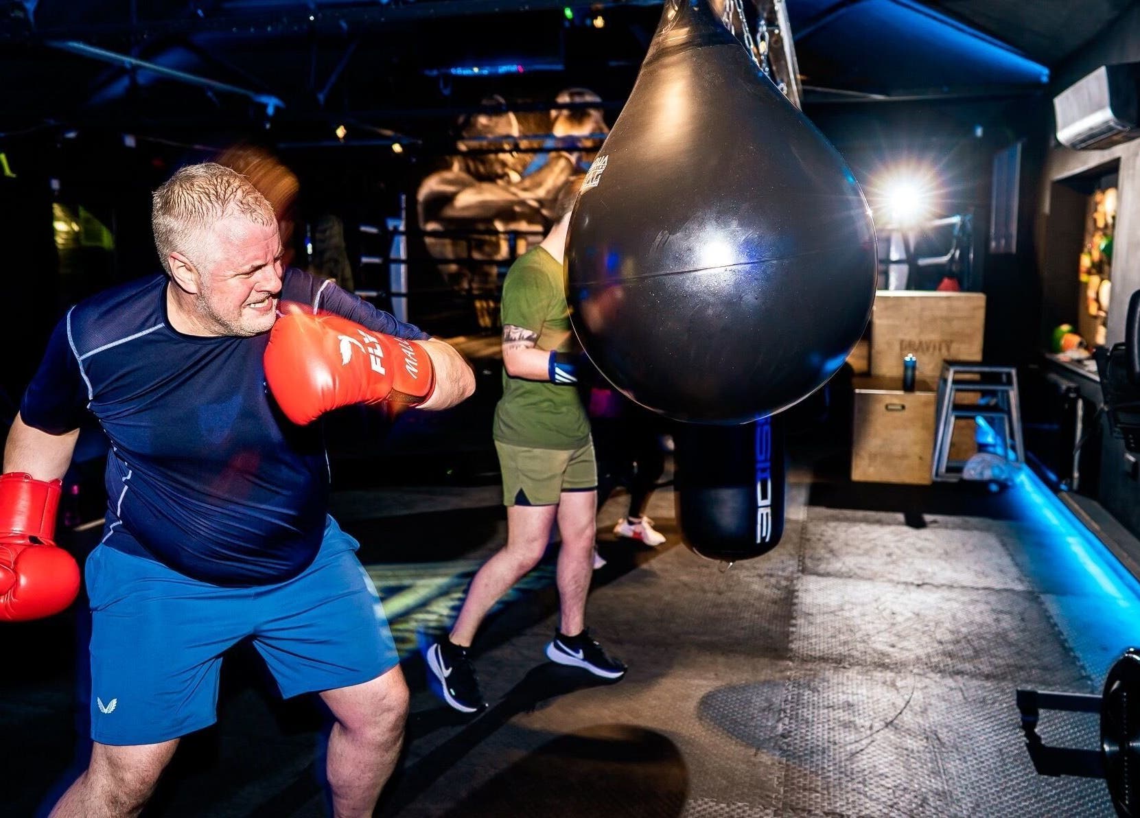 Man boxing at Conquer Boxing & Fitness, Ormskirk, England. Engaged in punching bag workout.