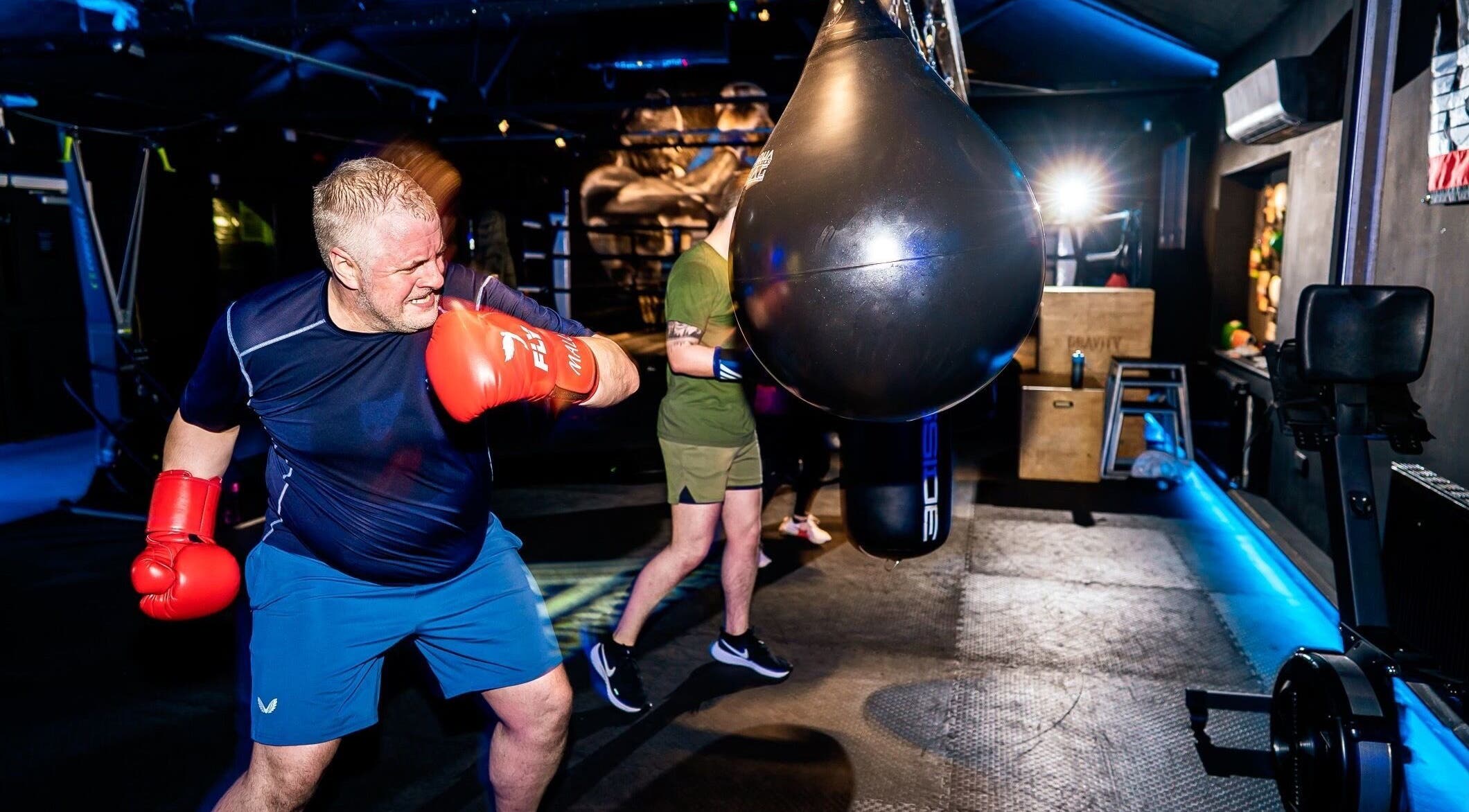 Man boxing at Conquer Boxing & Fitness, Ormskirk, England. Engaged in punching bag workout.