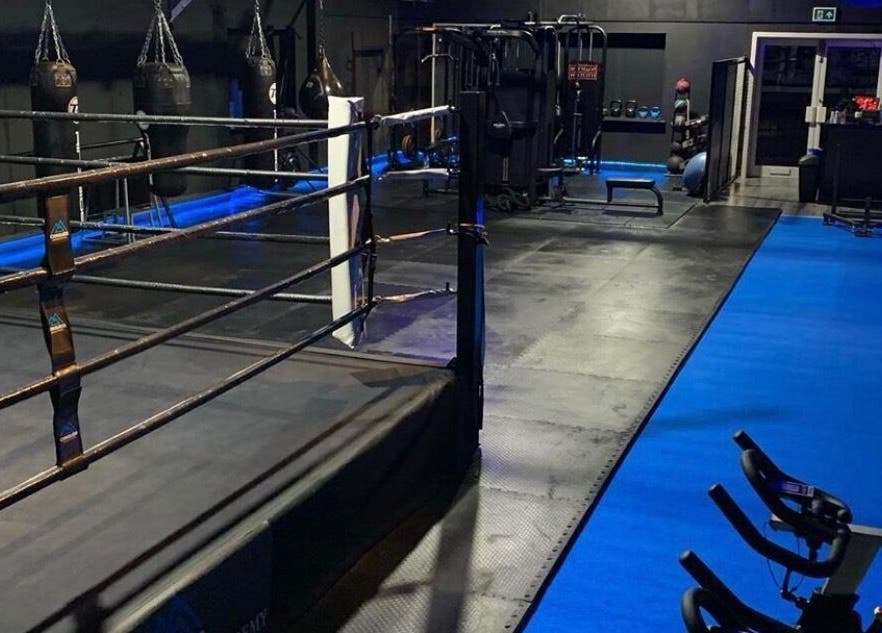 Interior of Conquer Boxing & Fitness in Ormskirk, England with boxing ring and equipment.