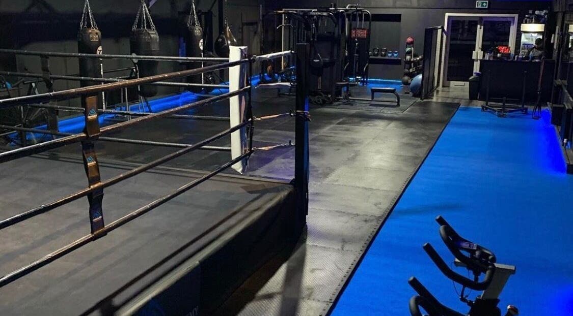 Interior of Conquer Boxing & Fitness in Ormskirk, England with boxing ring and equipment.
