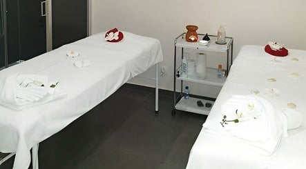 Sala de massagem dupla no Amor de Pele em Amadora, Lisboa, PT, com mesas brancas e decoração relaxante.