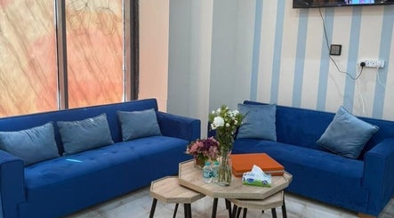 Queens Salon lounge area with blue sofas in Ajman, Ajman, AE, creating a welcoming atmosphere.
