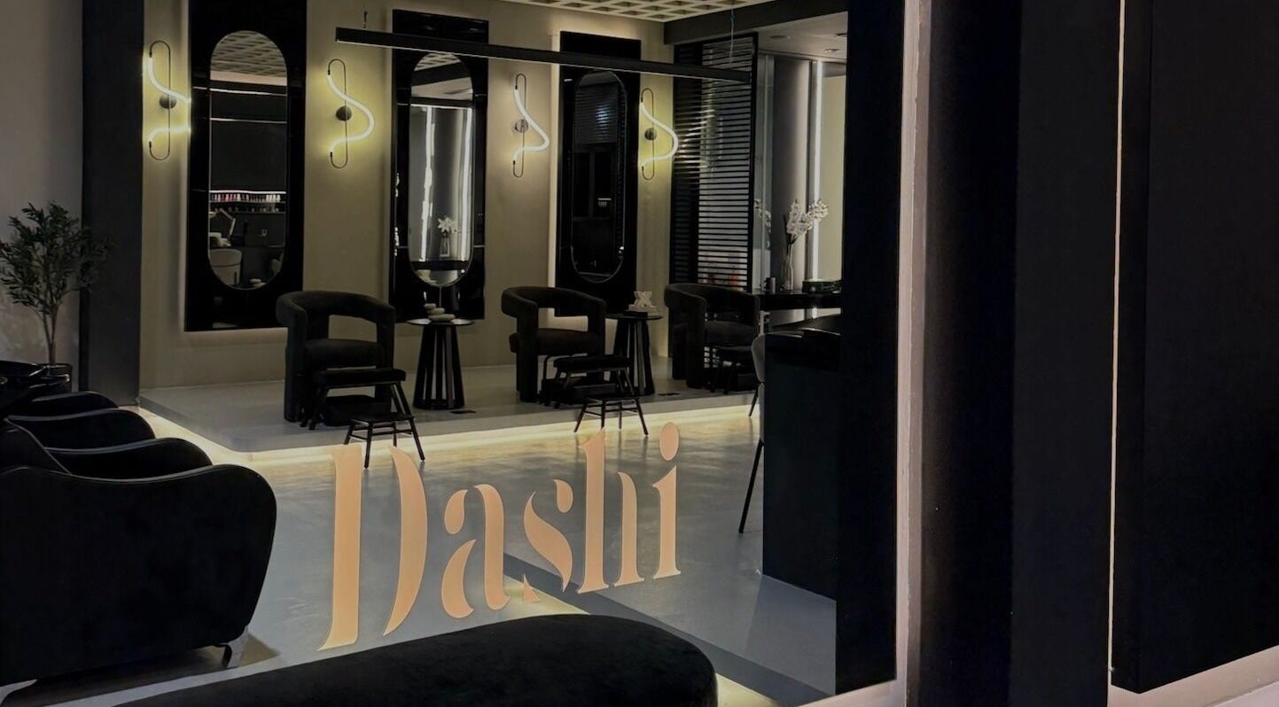Modern interior of DASHI Beauty in Seeb, Muscat Governorate, OM with chic black chairs and illuminated mirrors.