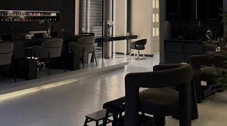 Elegant interior of DASHI Beauty in Seeb, Muscat Governorate, OM featuring modern black decor and styling stations.