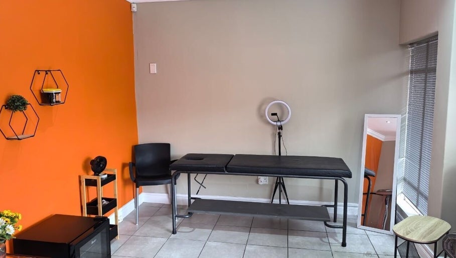 Calm treatment room at NASIMISA: Health & Wellness Hub, Pretoria, Gauteng, ZA with orange accent wall.