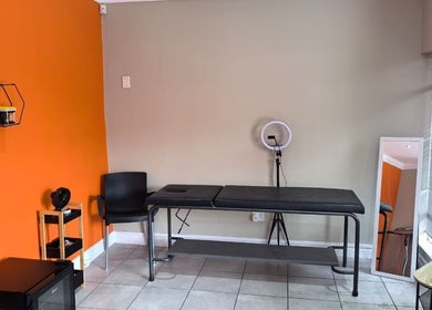 Calm treatment room at NASIMISA: Health & Wellness Hub, Pretoria, Gauteng, ZA with orange accent wall.