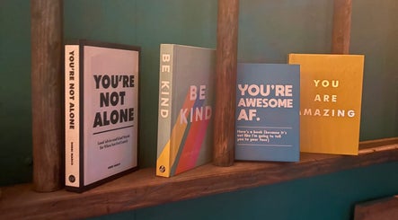 Motivational books on display at Velvet Tattoos, Dunsdale, England, GB, offering uplifting messages.