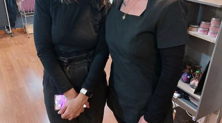 Two women at Tailored Nails & Lashes, Cape Town, Western Cape, ZA, standing in a warm, inviting salon setting.