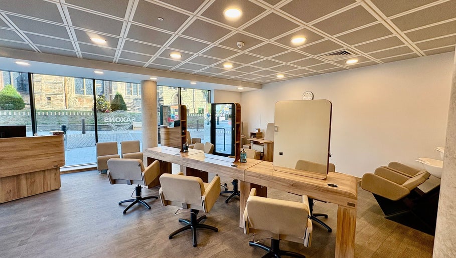 Modern salon interior at Saxons at Tamworth College, Tamworth, England, GB featuring stylish chairs and mirrors.