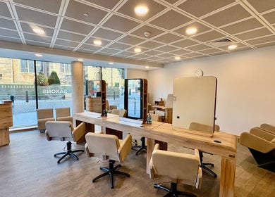 Modern salon interior at Saxons at Tamworth College, Tamworth, England, GB featuring stylish chairs and mirrors.