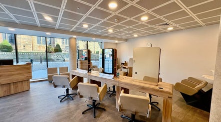 Modern salon interior at Saxons at Tamworth College, Tamworth, England, GB featuring stylish chairs and mirrors.