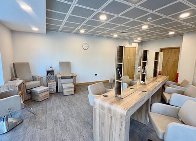 Modern salon interior at Saxons at Tamworth College in Tamworth, England, GB featuring plush seating and wooden decor.