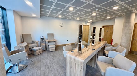 Modern salon interior at Saxons at Tamworth College in Tamworth, England, GB featuring plush seating and wooden decor.