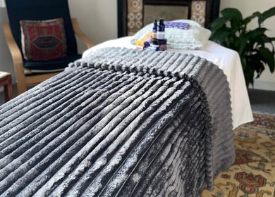 Cozy treatment room at Her Sanctuary Holistic Therapies, Leeds, England, GB, featuring a plush gray blanket.