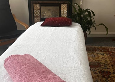 Cozy therapy room at Her Sanctuary Holistic Therapies, Leeds, England, GB with massage table and chair.